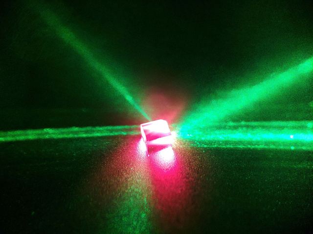Green pump laser beams crossing a red-fluorescing diamond sample