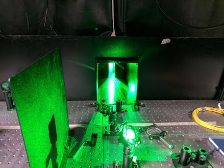 The optical bench, with green pump laser light and beam-shaping optics